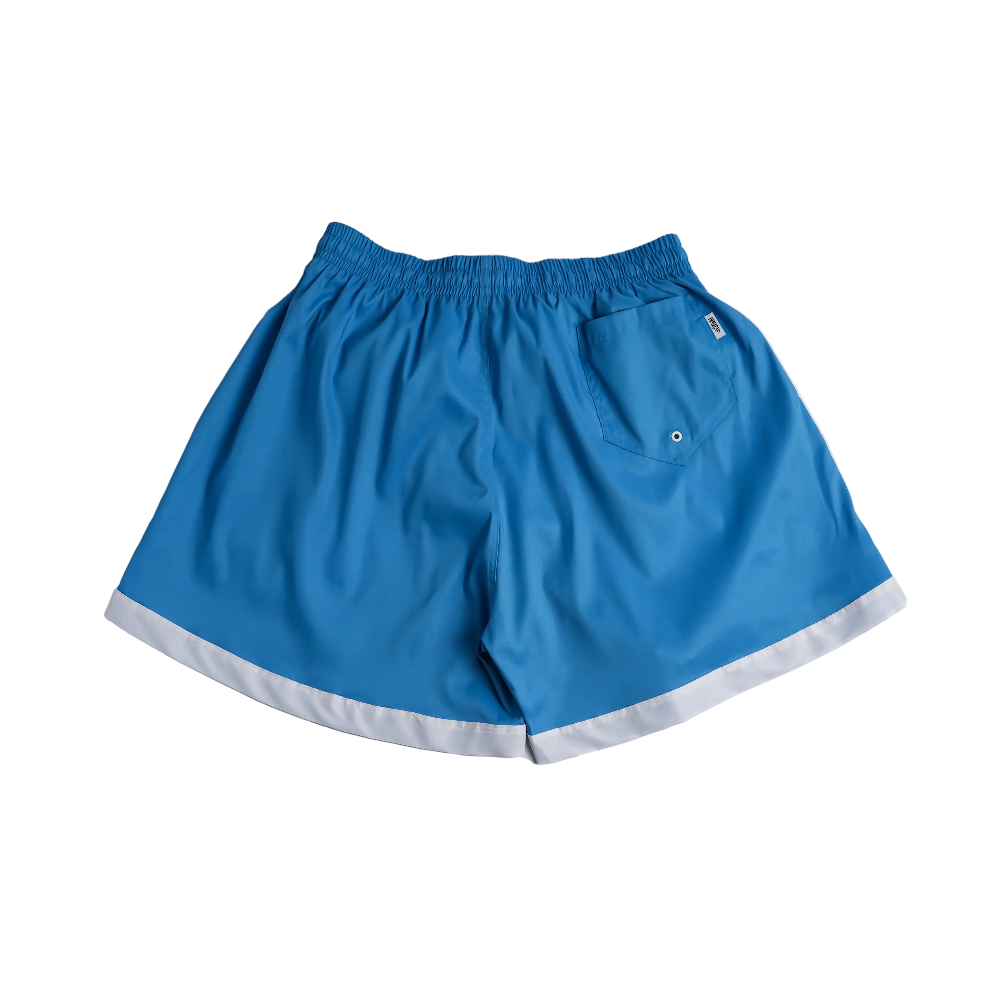 Blue athletic shorts with a white contrast hem and a side pocket, laid flat on a light gray background.